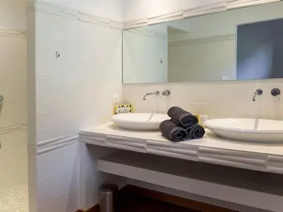 a bathroom with two sinks and a large mirror at Villa Palombaggia in Porto-Vecchio