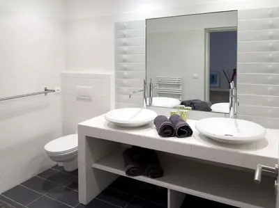 a bathroom with two sinks and a toilet and a mirror at Villa Palombaggia in Porto-Vecchio