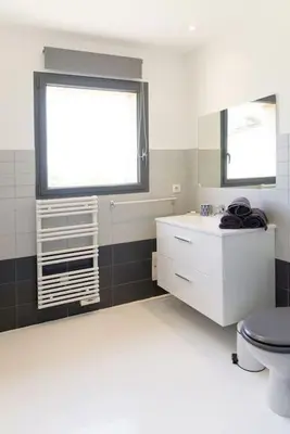 a bathroom with a toilet and a window and a sink at Villa Palombaggia in Porto-Vecchio
