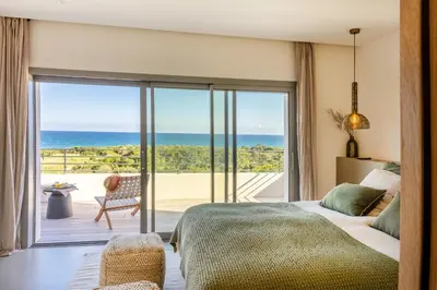 a bedroom with a bed and a view of the ocean at Villa Yaya in Cervione