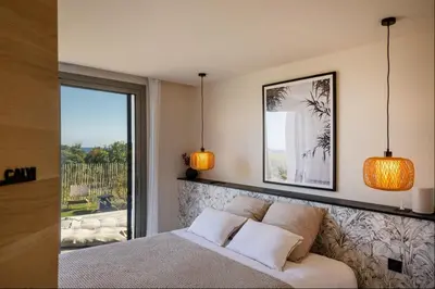 a bedroom with a bed with two lamps and a window at Villa Yaya in Cervione