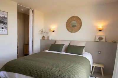 a bedroom with a bed and a mirror on the wall at Villa Yaya in Cervione
