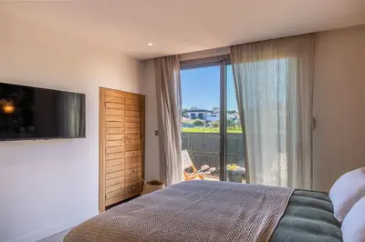 a bedroom with a bed and a large window at Villa Yaya in Cervione