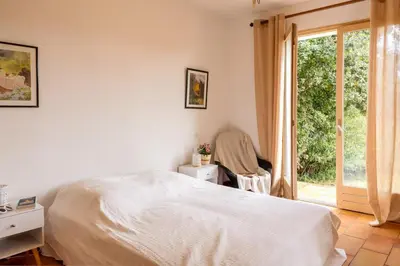 a white bedroom with a bed and a window at Villa Josiane in San-Nicolao