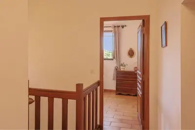 a hallway with a staircase and a window and a dresser at Villa Josiane in San-Nicolao
