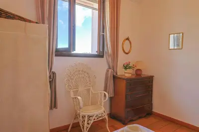 a room with a chair and a dresser and a window at Villa Josiane in San-Nicolao