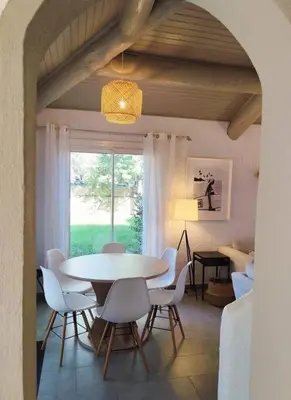 a dining room with a table and chairs and a window at Villa Cosy, 75m2, climatisé, 200m plage, parking in Lecci