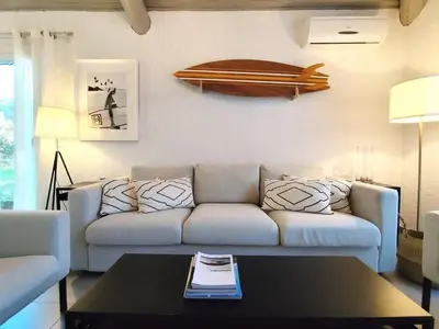 a living room with a couch and a table at Villa Cosy, 75m2, climatisé, 200m plage, parking in Lecci