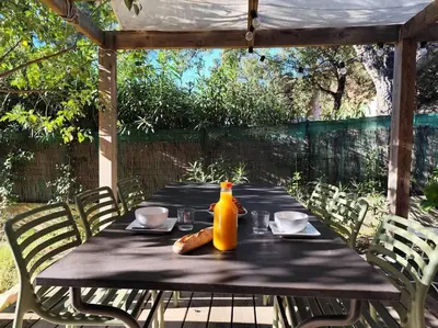 a table with a bottle of orange juice and a hot dog on it at Villa Cosy, 75m2, climatisé, 200m plage, parking in Lecci