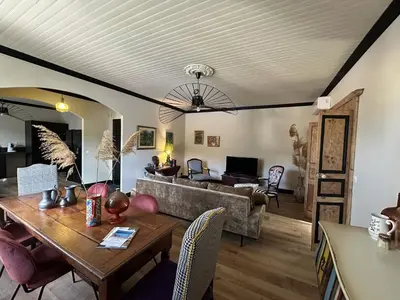 a living room with a table and a couch at Appartement de charme vue mer in Kamiesch