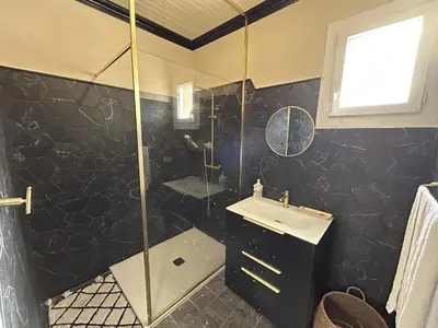 a bathroom with a shower and a sink at Appartement de charme vue mer in Kamiesch