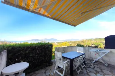 a patio with a table and chairs and a grill at Nice quiet accommodation in Grosseto-Prugna in Grosseto-Prugna