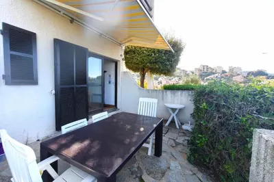 a wooden table and chairs on the patio of a house at Nice quiet accommodation in Grosseto-Prugna in Grosseto-Prugna