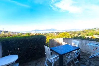 a table and chairs on a patio with a view at Nice quiet accommodation in Grosseto-Prugna in Grosseto-Prugna