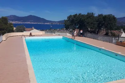 a large blue swimming pool with people standing around it at Nice quiet accommodation in Grosseto-Prugna in Grosseto-Prugna