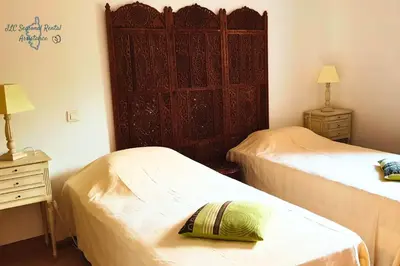 a bedroom with two beds and a large wooden cabinet at A Casa Apa Vue mer Plage a pied Ruppione Pietrosella in Pietrosella