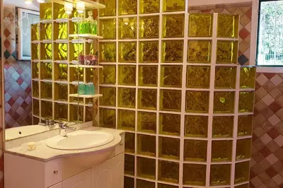 a bathroom with a sink and a green tiled wall at A Casa Apa Vue mer Plage a pied Ruppione Pietrosella in Pietrosella