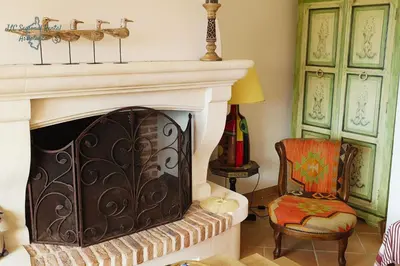 a living room with a fireplace and a chair at A Casa Apa Vue mer Plage a pied Ruppione Pietrosella in Pietrosella
