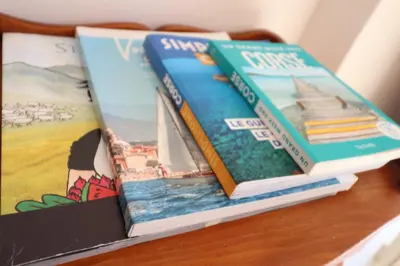 three books sitting on top of a table at LE FINOSELLO - T2 Cosy sur Ajaccio avec Clim, Wifi & Parking - proche Port & Aéroport in Ajaccio