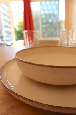 two bowls sitting on a table with a window at LE FINOSELLO - T2 Cosy sur Ajaccio avec Clim, Wifi & Parking - proche Port & Aéroport in Ajaccio