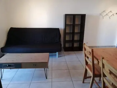 a living room with a couch and a wooden table at Studio calme proche de la gare de Borgo in Borgo