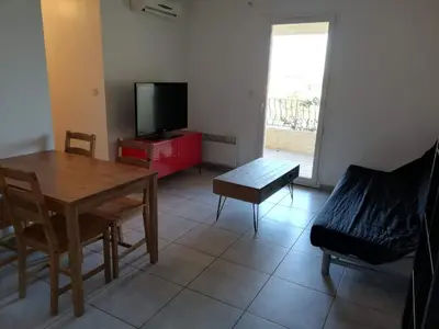 a living room with a television and a table and chairs at Studio calme proche de la gare de Borgo in Borgo