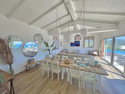 a dining room with a table and chairs at Maison Bord'eau in Sainte-Lucie de Porto-Vecchio