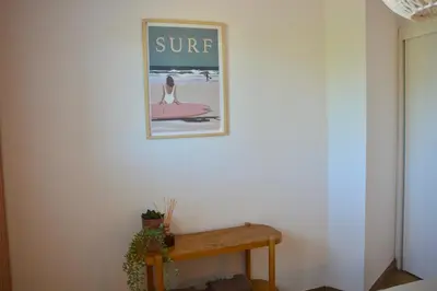 a picture of a woman on a surfboard on a wall at Maison Bord'eau in Sainte-Lucie de Porto-Vecchio