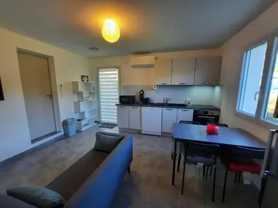 a kitchen and living room with a couch and a table at F2 Alata proche d'Ajaccio rez-de-villa in Alata