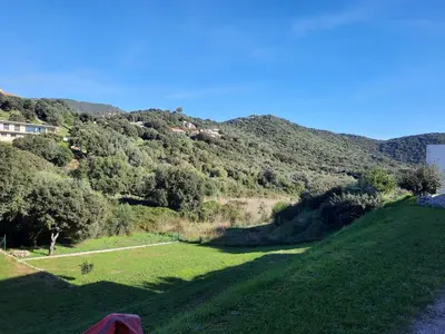 a grassy field with a mountain in the background at F2 Alata proche d'Ajaccio rez-de-villa in Alata