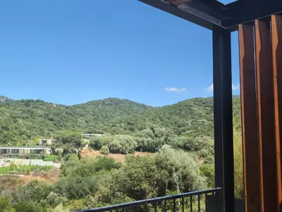 a view of the mountains from the balcony of a house at Duplex neuf T3 terrasse et jardin proche plages in Pietrosella