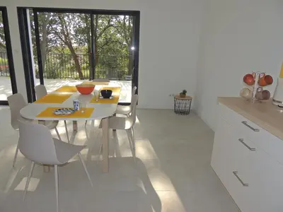 a kitchen with a yellow table and white chairs at Villa neuve à 900 m de la plage in Santa-Lucia-di-Moriani