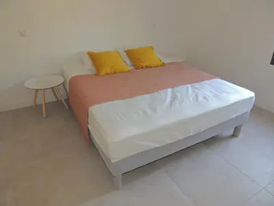 a bed with two yellow pillows on it in a room at Villa neuve à 900 m de la plage in Santa-Lucia-di-Moriani