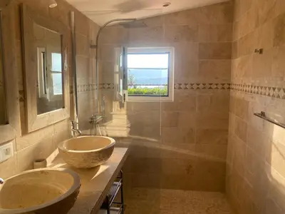 a bathroom with two sinks and a window at Villa vue mer exceptionnelle à 500m de la plage de Santa Giulia in Porto-Vecchio