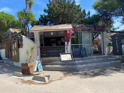 a restaurant with a sign in front of a building at Villa vue mer exceptionnelle à 500m de la plage de Santa Giulia in Porto-Vecchio