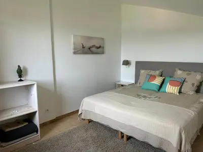 a bedroom with a bed with colorful pillows on it at Villa vue mer exceptionnelle à 500m de la plage de Santa Giulia in Porto-Vecchio
