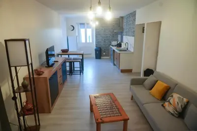 a living room with a couch and a table at Location F2 44 m2 in Venaco