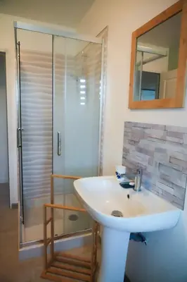 a bathroom with a white sink and a shower at Location F2 44 m2 in Venaco