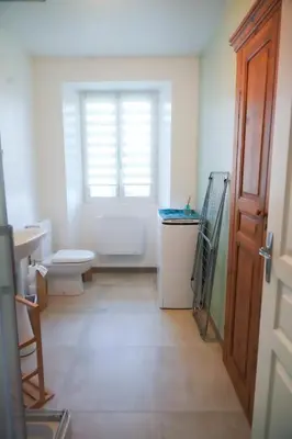 a bathroom with a toilet and a window at Location F2 44 m2 in Venaco