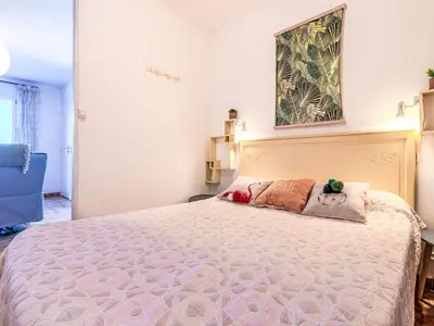 a bedroom with a large bed and a painting on the wall at Apartment T1 Gabriello by Interhome in Cala dʼOro