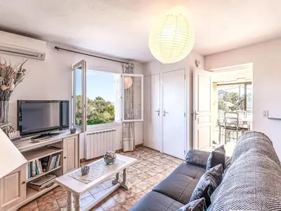 a living room with a couch and a tv at Apartment T1 Gabriello by Interhome in Cala dʼOro