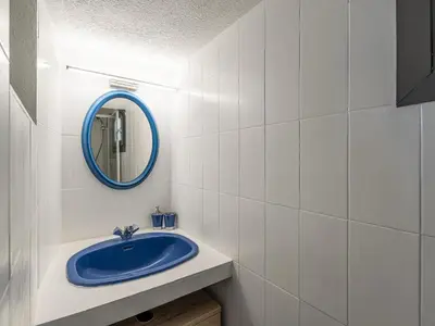 a bathroom with a blue sink and a mirror at Villa Villa Sallena by Interhome in Porto-Vecchio