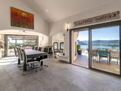 a dining room with a table and a view of the ocean at Villa Villa Sallena by Interhome in Porto-Vecchio