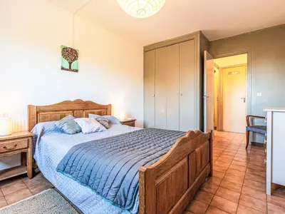 a bedroom with a large wooden bed in a room at Apartment T2 Gabriello by Interhome in Cala dʼOro