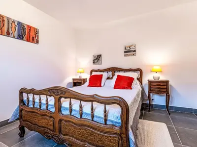 a bedroom with a wooden bed with red pillows at Holiday Home Casa Santa Reparata by Interhome in Santa-Reparata-di-Moriani