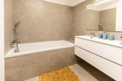 a bathroom with a bath tub and a sink at Appartement T3 Porto Vecchio in Porto-Vecchio