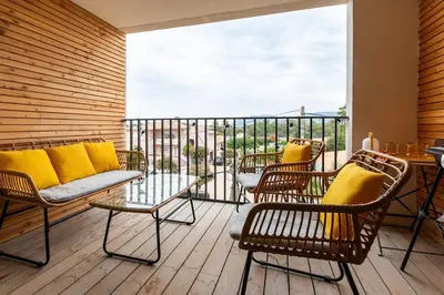 a balcony with a couch and chairs on a balcony at Appartement T3 Porto Vecchio in Porto-Vecchio