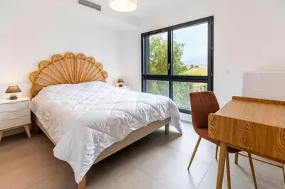 a bedroom with a large bed and a window at Appartement T3 Porto Vecchio in Porto-Vecchio