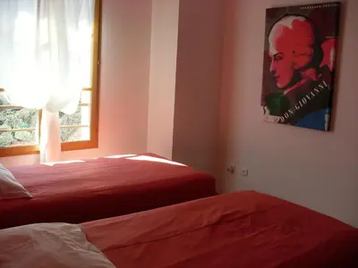 a bedroom with two beds and a window and a poster at Côté Lac Tolla in Tolla