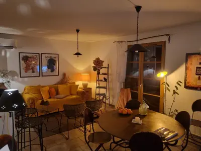 a living room with a couch and tables and chairs at Côté Lac Tolla in Tolla